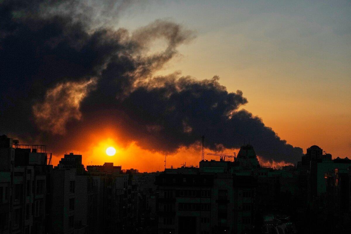 The sun sets behind a plume of smoke rising after a U.S.–Israeli military strike in Tehran, Iran, on March 3, 2026. (Vahid Salemi/AP Photo)