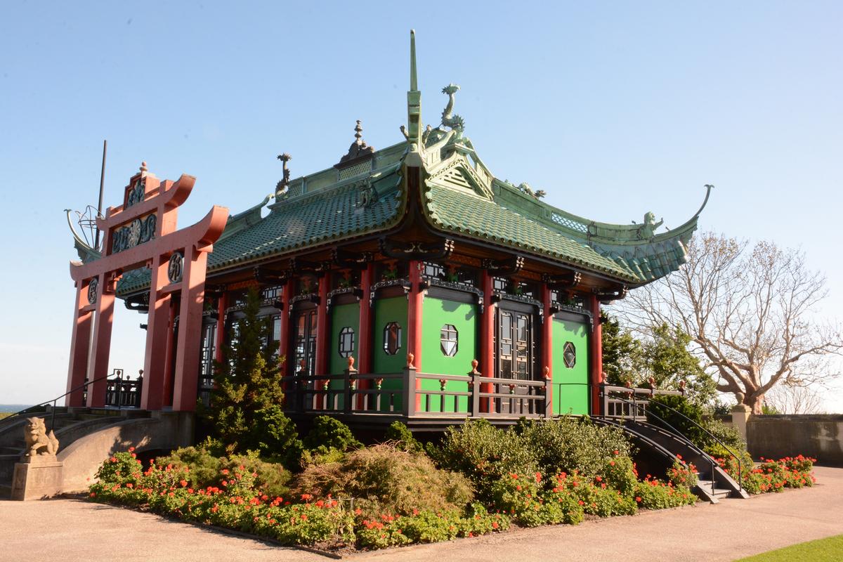 Built in 1914, The Chinese Tea House draws from 12th-century temple architecture, featuring projecting ribs and a jade green terra-cotta roof with curved eave tips. It served as both an ornamental retreat and a social gathering space. Inside, deep-toned wooden paneling lines the walls, and pilasters are inscribed with Chinese proverbs personally selected by Alva, including: "As for exaggerations of speech, they carry with them a cartload of demons." (The Preservation Society of Newport County)