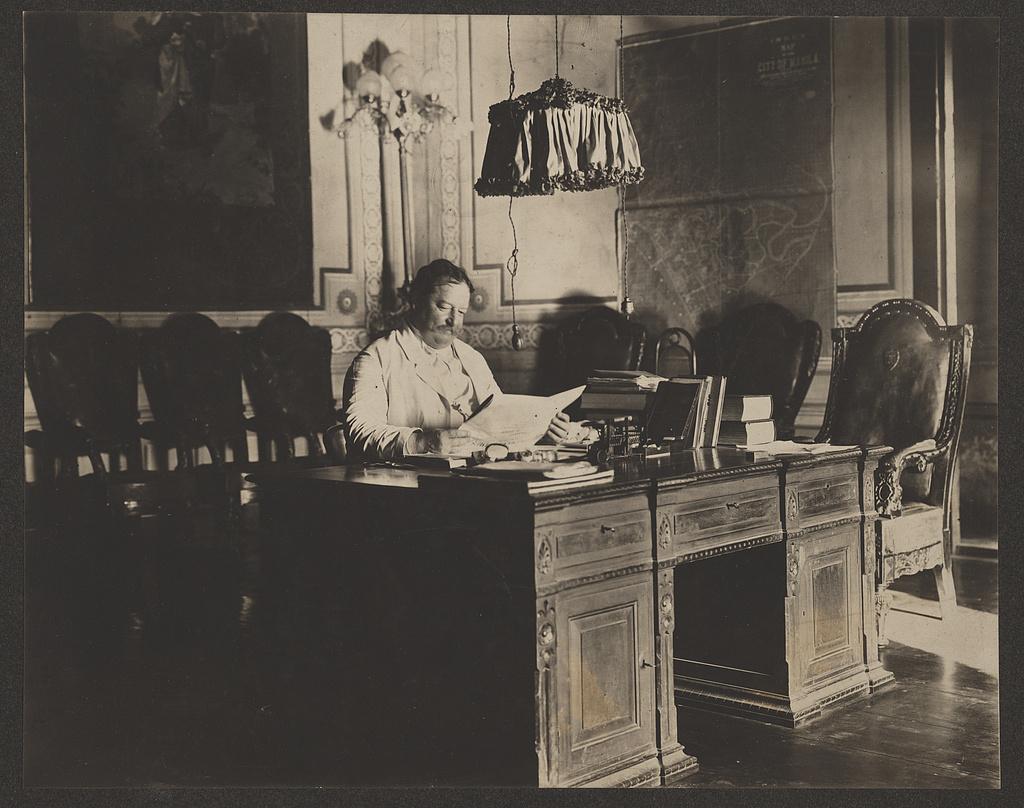 William H. Taft, governor-general of the Philippines, seated at desk in office with map of Manila on the wall. Library of Congress. (Public Domain)