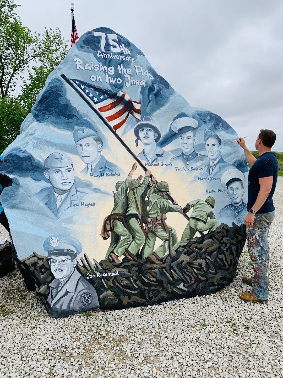 Sorensen stands beside a rock depicting the flag-raising in the Battle of Iwo Jima. (Sorensen Studios)