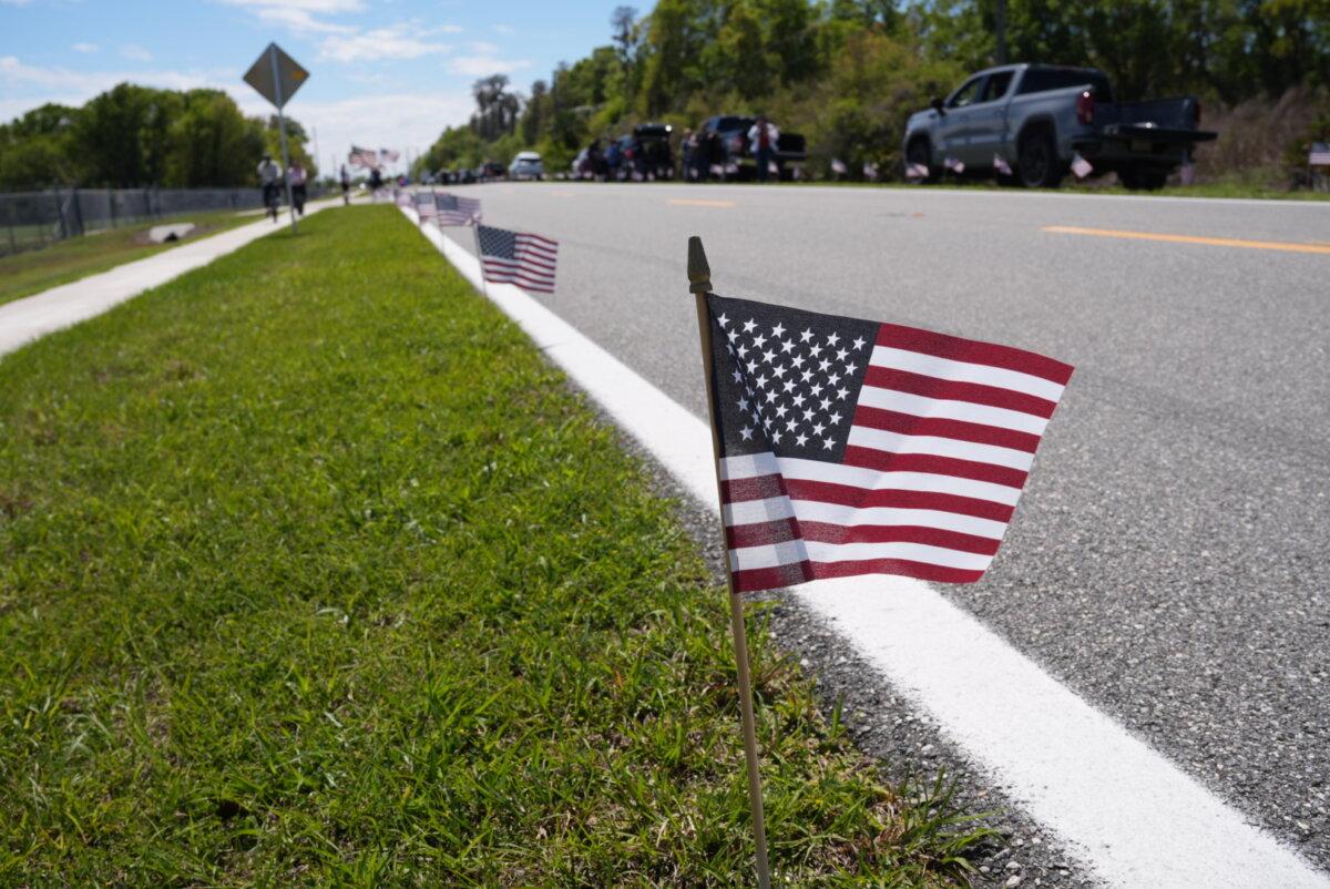 Hundreds of American flags lined the roadways for the funeral procession of Major Cody Khork, who was killed in the ongoing Iran War. The ceremony took place in Winter Haven, Fla., on March 18, 2026. (Troy Myers/The Epoch Times)