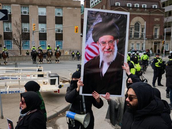 Protesters hold a portrait of former Iranian Supreme Leader Ayatollah Ali Khamenei as they demonstrate by the U.S. Consulate during a rally for Al-Quds Day, in Toronto, Canada, on March 14, 2026. (Sammy Kogan/The Canadian Press)