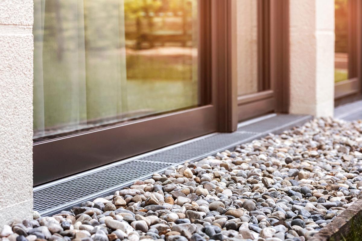 Ground-based drainage solutions, such as French drains, redirect water away from the foundations and help manage heavy runoff. (Mariana Serdynska/Shutterstock)