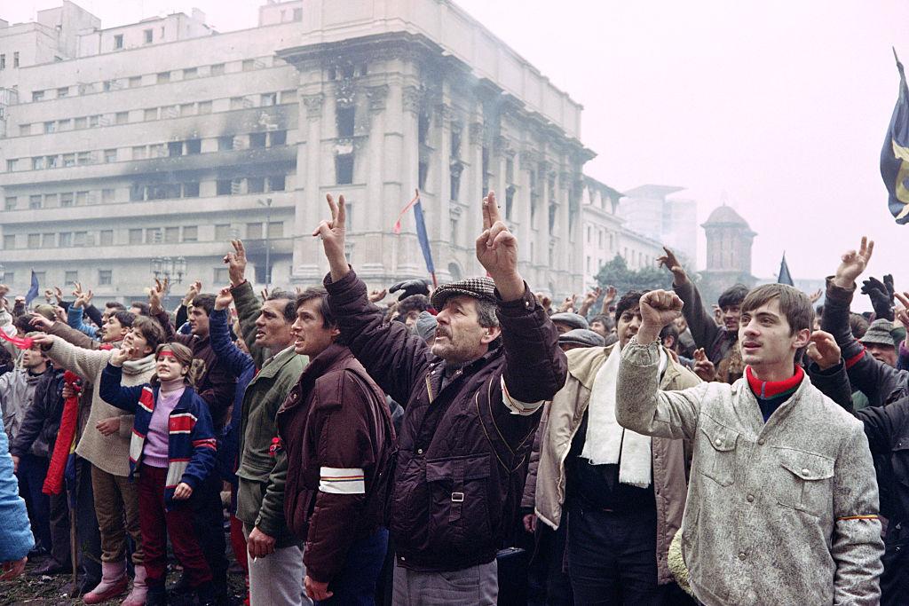 Romanian civilians show the victory sign in a demonstration supporting the overthrow of the communist regime in Romania in 1989. (Christophe Simon and Joel Robine/AFP via Getty Images)