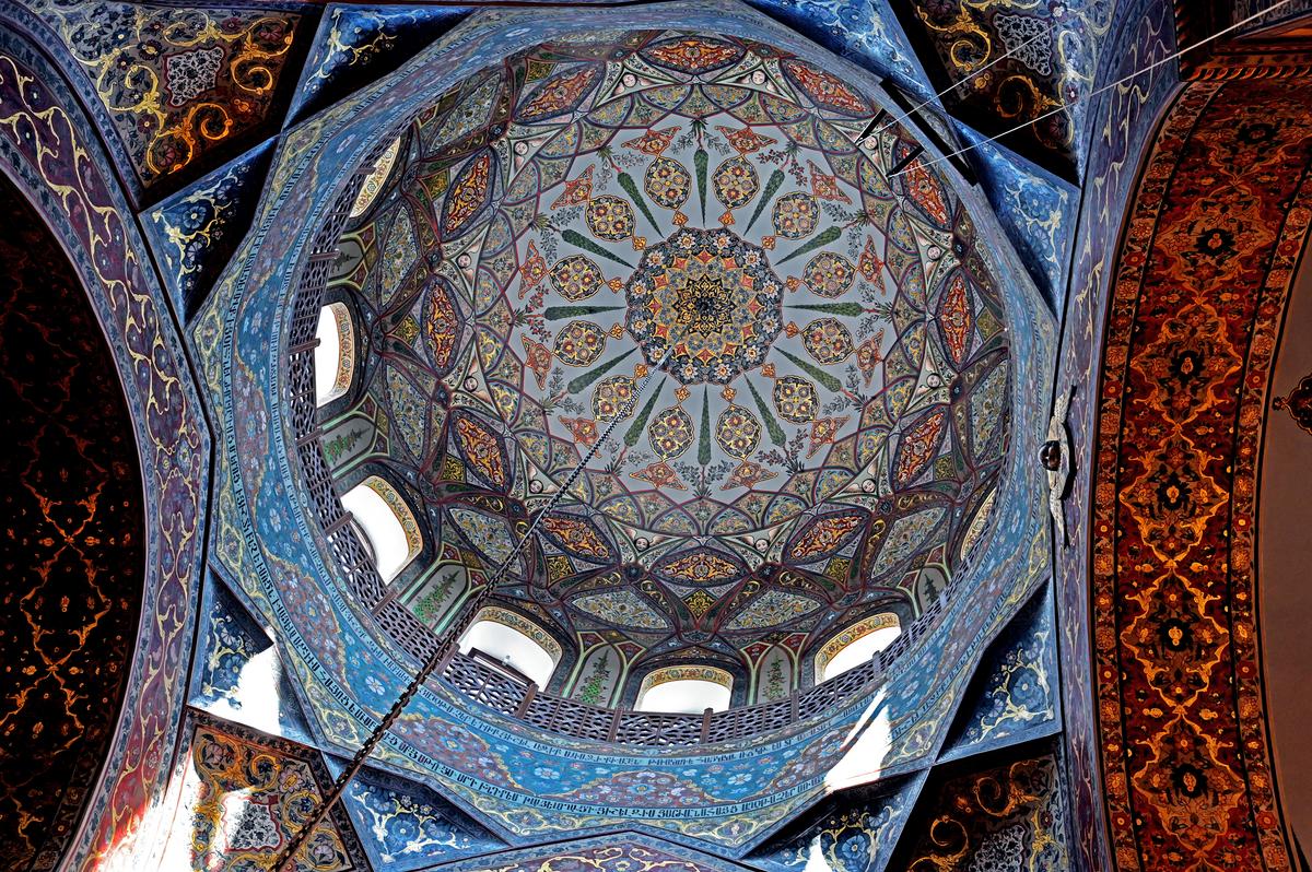 Filling every space of Etchmiadzin Cathedral’s cupola are lavish, jewel-toned fresco paintings covered in gold leaf. Around what is considered the vent section of the cupola, between the cap and the base, are arched windows and a ring of latticework. Gothic arch shapes married with floral designs achieve a one-of-a-kind, opulent presentation inside this dome. (<a title="User:Soghomon Matevosyan" href="https://commons.wikimedia.org/wiki/User:Soghomon_Matevosyan">Soghomon Matevosyan</a>/<a title="Category:CC-BY-SA-4.0" href="https://commons.wikimedia.org/wiki/Category:CC-BY-SA-4.0">CC-BY-SA-4.0</a>)