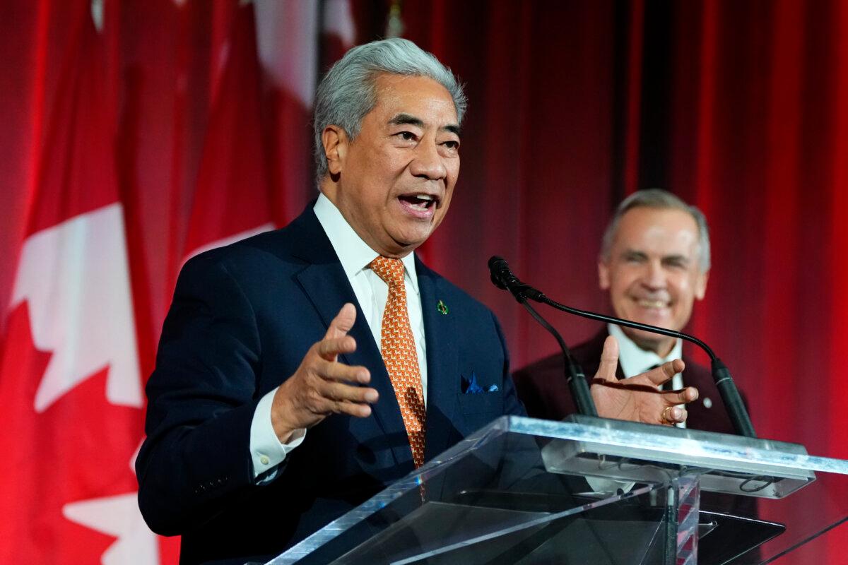 MP Michael Ma, who crossed the floor from the Conservatives to the Liberals, makes brief remarks alongside Prime Minister Mark Carney at the Liberal caucus holiday party in Ottawa on Dec. 11, 2025. (The Canadian Press/Justin Tang)