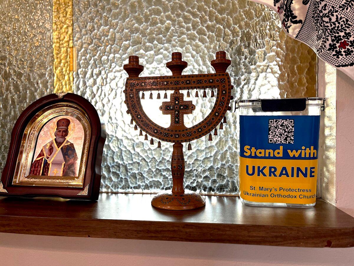 A collection for the Ukraine relief effort box sits beside religious artifacts at St. Mary's Protectress Ukrainian Orthodox Church in Phoenix on Jan. 30, 2026. (Allan Stein/The Epoch Times)