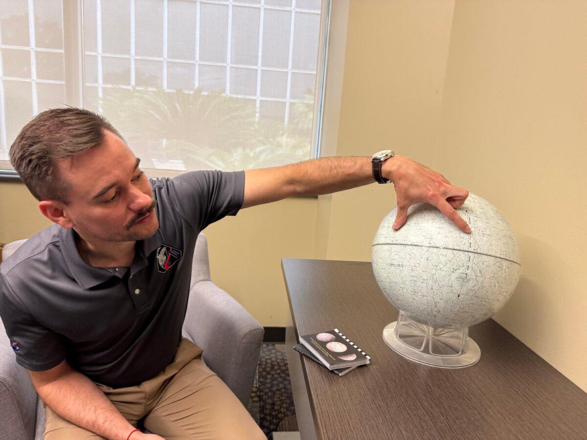 Jacob Richardson, Artemis II’s deputy lunar science lead, indicates roughly how much of the moon’s far side will be illuminated on April 5, 2026, ahead of Artemis II’s flyby. (T.J. Muscaro/The Epoch Times).