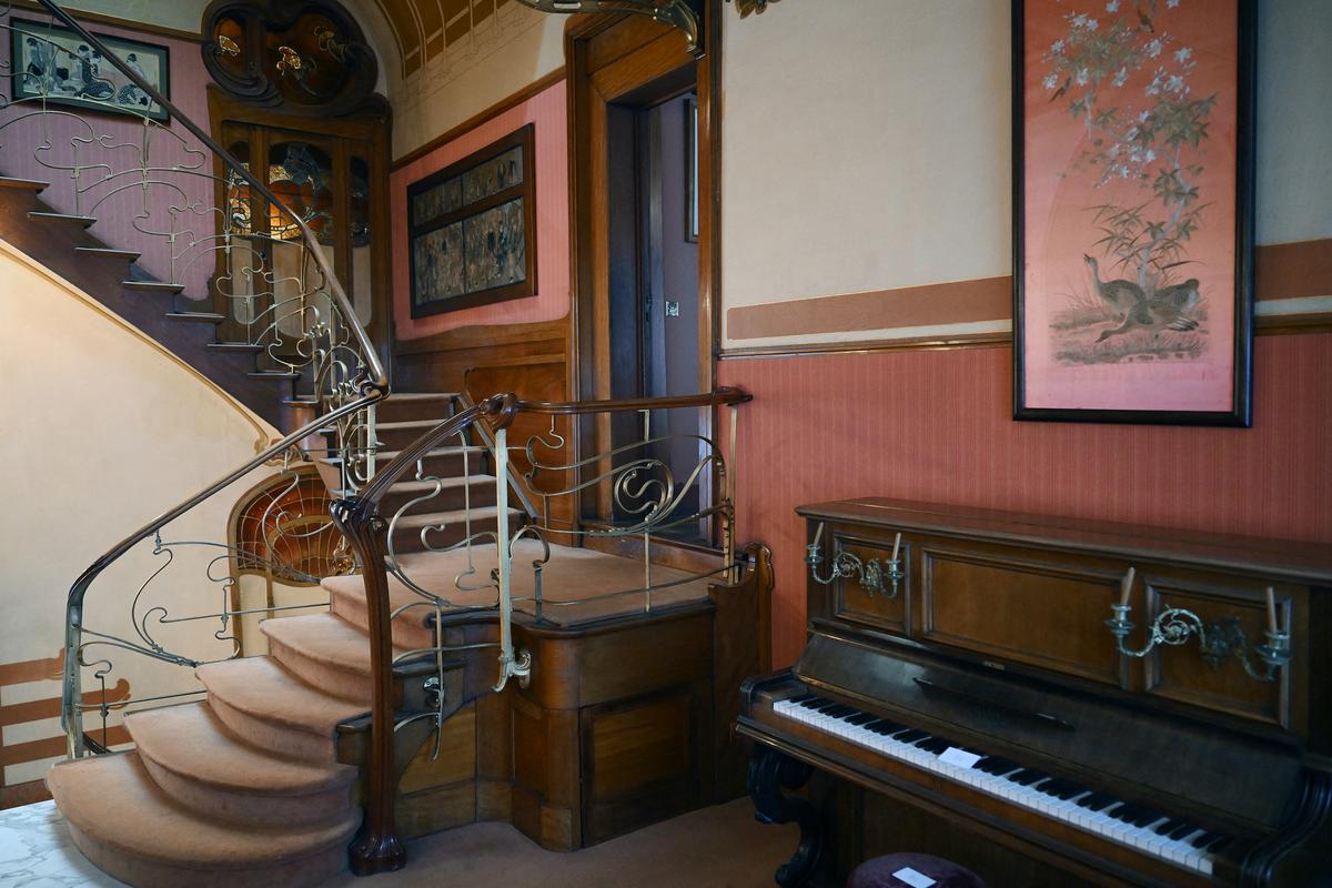 This first level opens onto the principal reception rooms, including the music room and dining room. The staircase features gently curving steps complemented by an intricately carved mahogany handrail, underscoring the refined restraint of the materials. Its smooth, organic woodwork pairs elegantly with the delicate iron detailing, creating a balanced and cohesive design. (Nicolas Tucat/Getty Images)