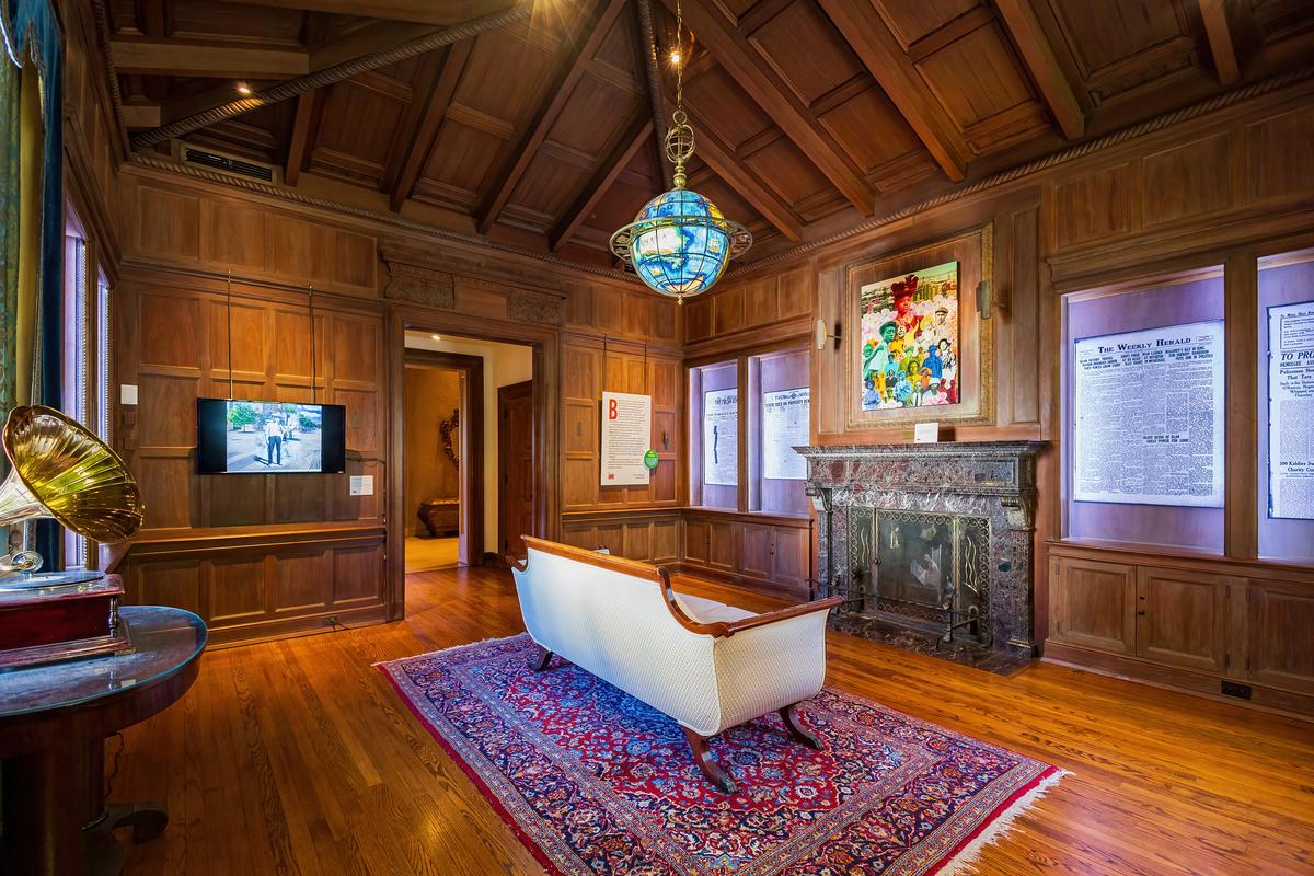 Dark walnut abounds on the library’s paneled walls and vaulted ceilings; polished red oak adorns the floors. Central in this all-wood room is a colorful globe light fixture featuring a reproduction world map from Leonardo da Vinci's time (mid-15th century to early 16th century). An empire-style sofa with wood trim faces the green and black marble fireplace. (Kit Leong/Shutterstock)