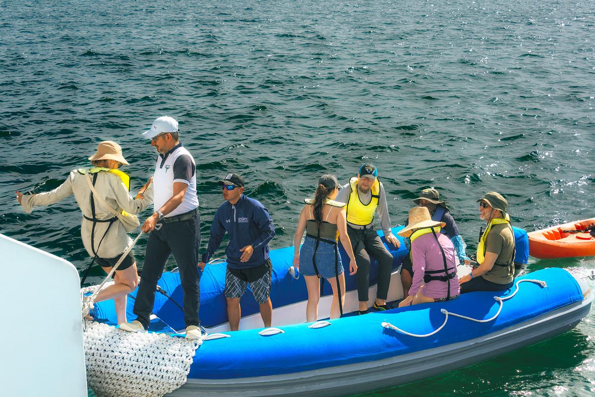 <span style="font-weight: 400;">Capt. Carlos Beliz helps a Seaman Journey passenger onto a Zodiac.</span> (Maria Coulson)