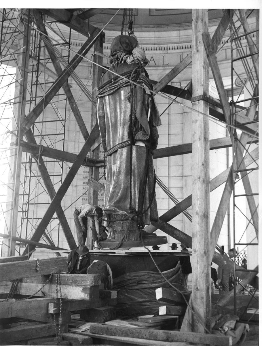 The bronze statue is lowered onto the pedestal in the chamber of the Jefferson Memorial. National Park Service. (Public Domain)