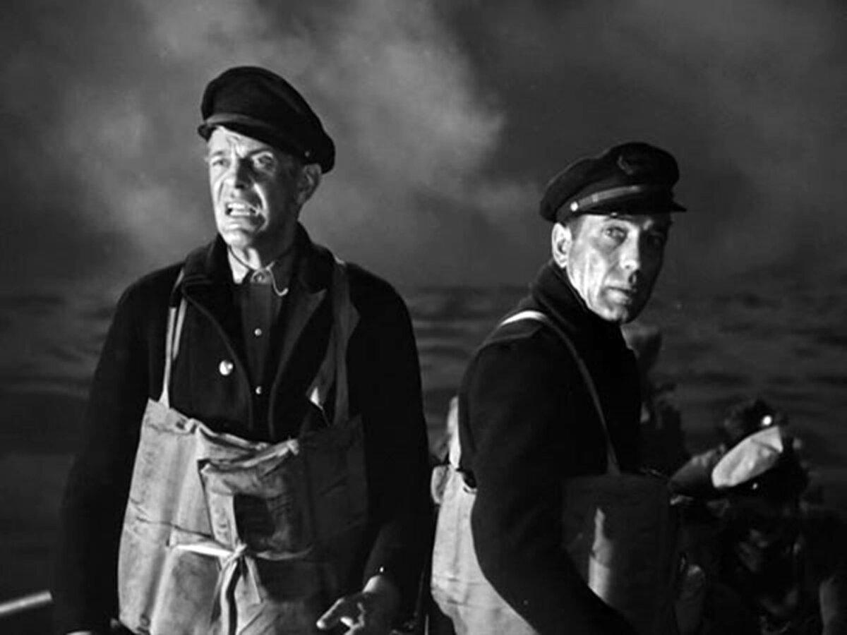 Capt. Steve Jarvis (Raymond Massey, L) and Joe Rossi (Humphrey Bogart), in “Action in the North Atlantic.” (Warner Bros. Pictures)