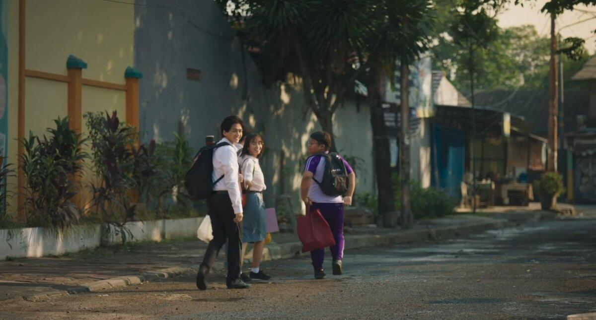 (L–R) Moko (Chicco Kurniawan) walks Nina (Freya JKT48) and Ano (Ahmad Nadif) to school, in “A Brother and 7 Siblings.” (Mandela Pictures)
