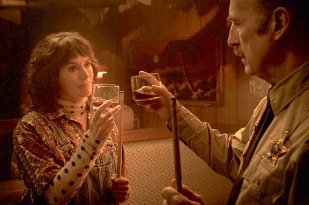 Moira (Lena Headey) and Ulysses (Bob Odenkirk) toast the town of Normal, in "Normal." (Magnolia Pictures)