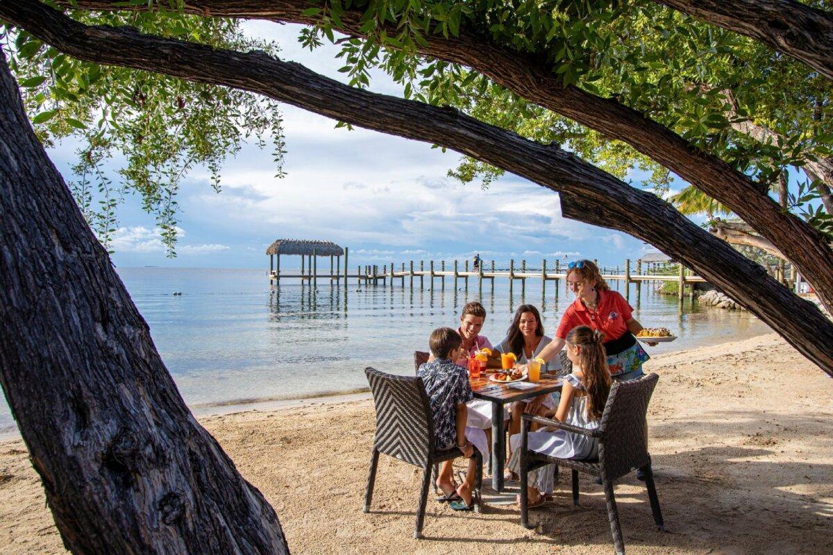 A family dines on the sand at popular Marker 88, where fish tacos are the order of the day. (Visit Florida Keys)