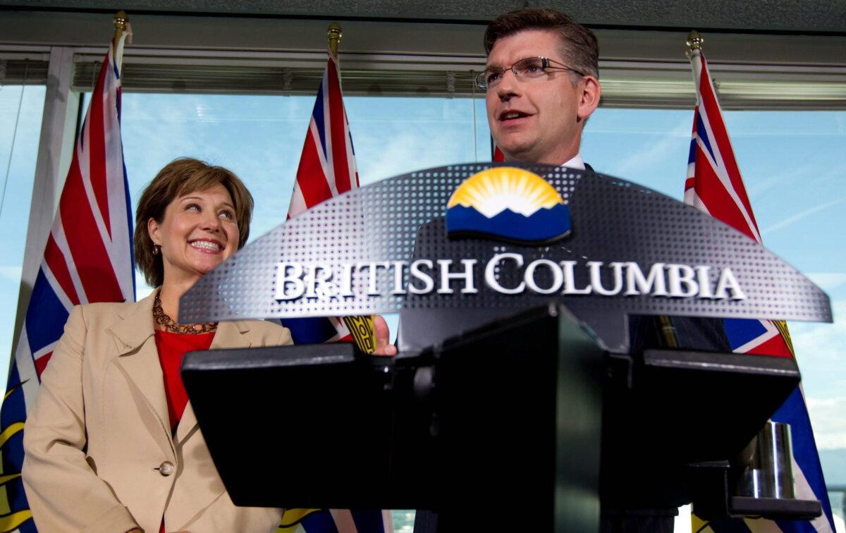 Then-B.C. Premier Christy Clark smiles as B.C. MLA Iain Black takes questions from the media after announcing he's stepping down, in Vancouver on Aug. 24, 2011. (The Canadian Press/Darryl Dyck)