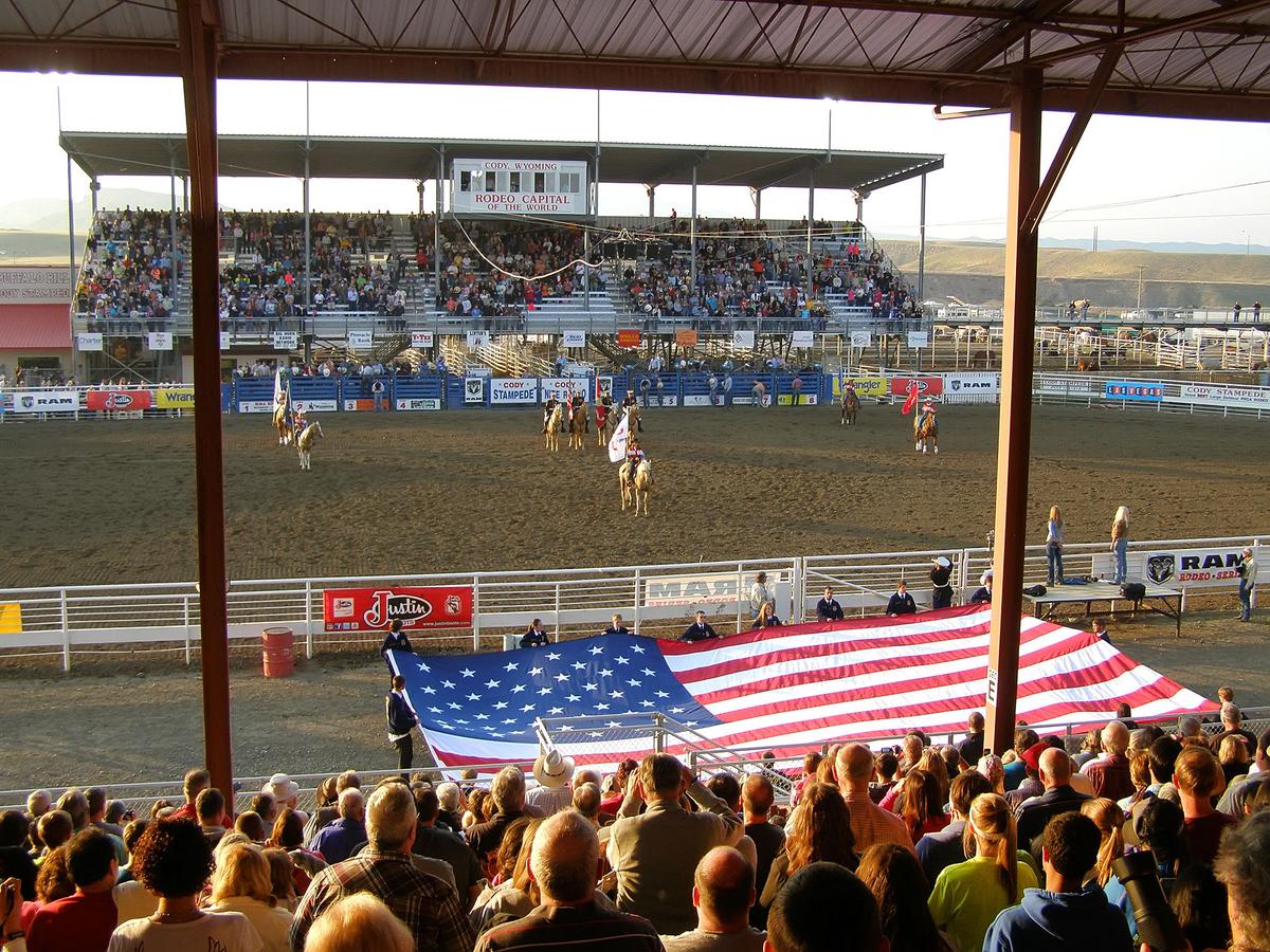 A rodeo's opening ceremony unfurls at the Cody Stampede Park in Cody, Wyoming. The Cody Rodeo takes place annually from June 1 through Aug. 31, with rodeos hosted each night. (Ukrolenochka/Shutterstock)