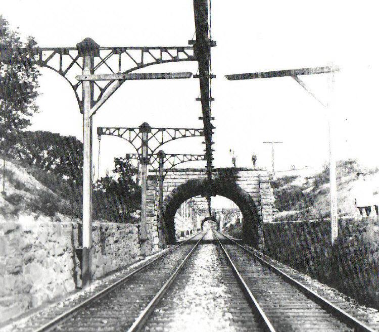 Original overhead third-rail system on the Baltimore Belt Line of the Baltimore & Ohio Railroad, part of the first mainline railroad electrification in 1895. Photo from 1901. (Public Domain)