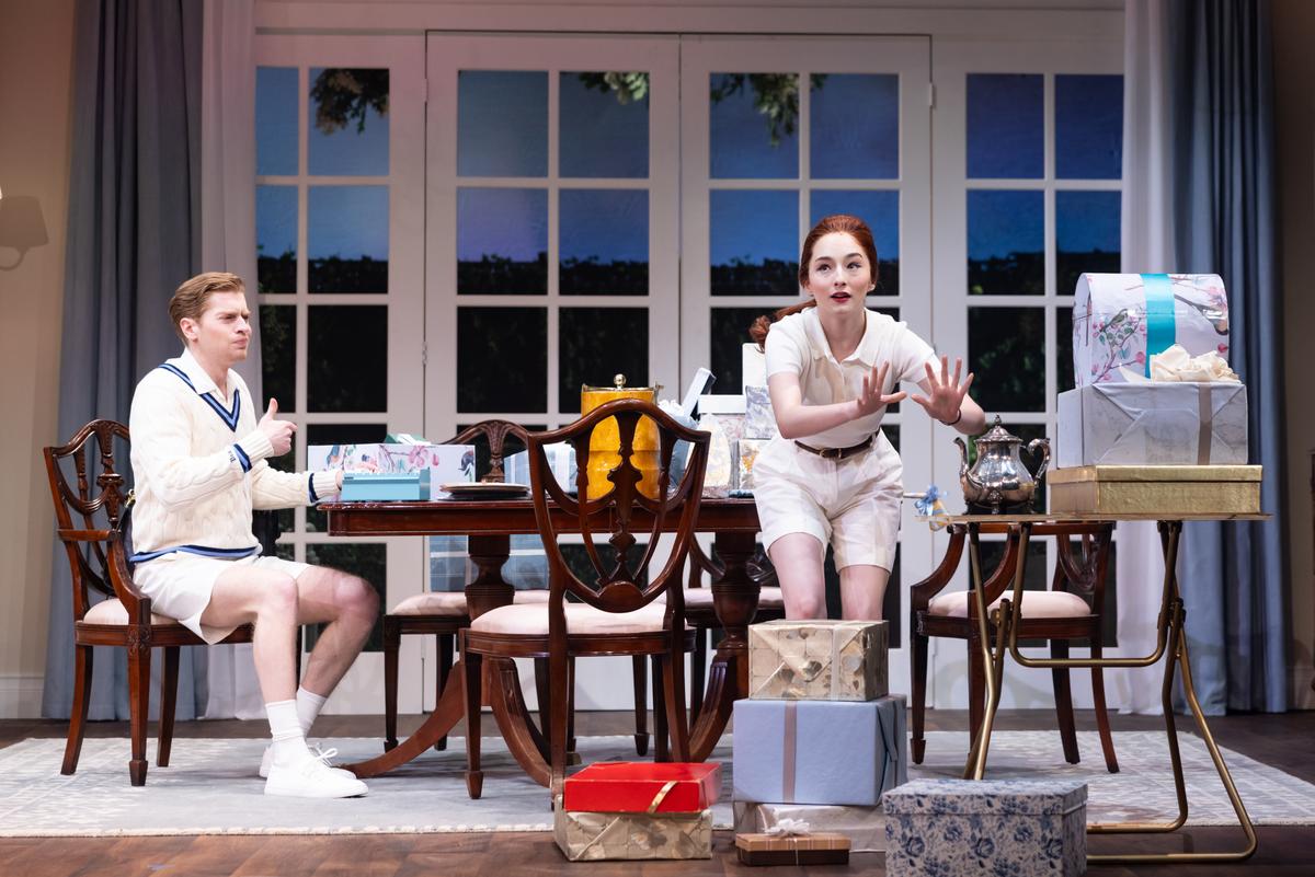 Ben (Kyle Ringley, L) sits with his sister Kay (Aurora Penepacker) as she opens gifts, in "Father of the Bride." (Justin Barbin)