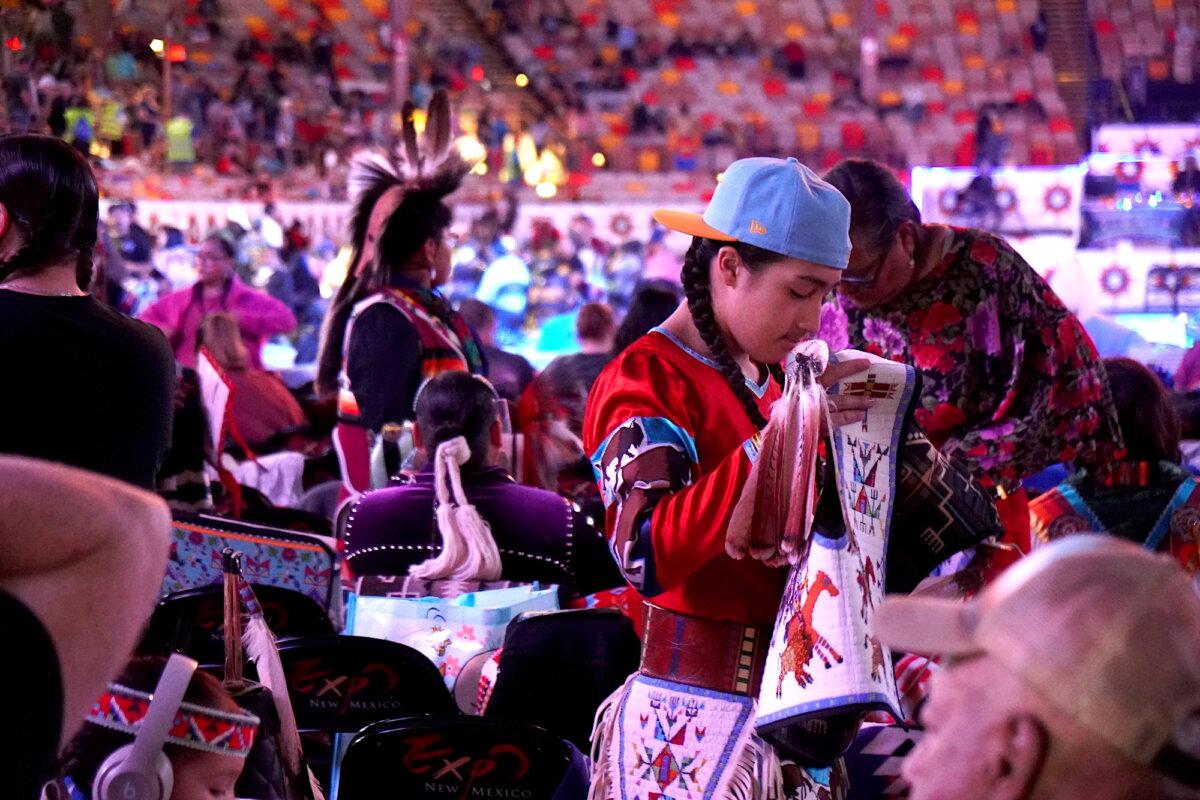 A traditional Native American performer prepares his costume during the final Gathering of Nations powwow in Albuquerque, N.M., on April 24, 2026. (Allan Stein/The Epoch Times)
