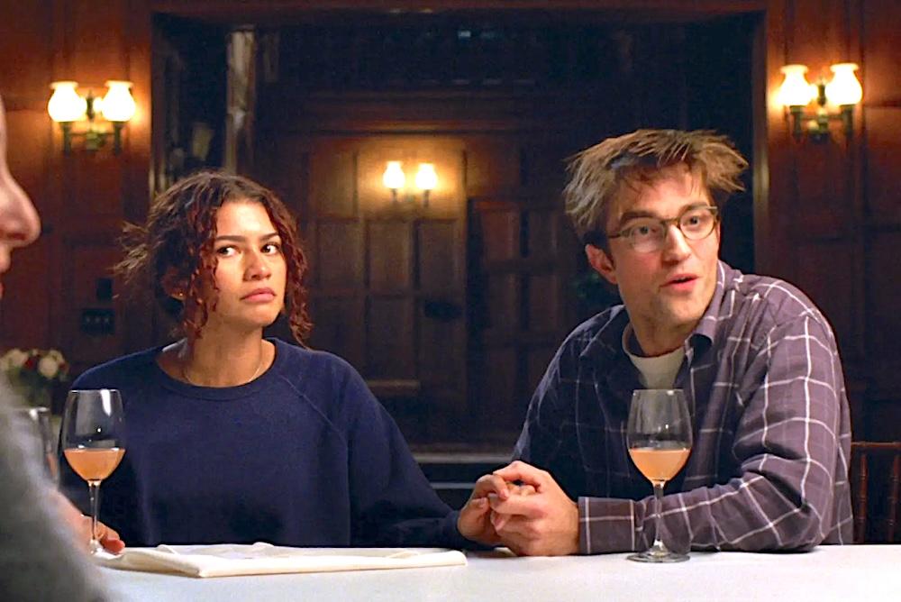 Betrothed couple Emma (Zendaya) and Charlie (Robert Pattinson) realizing things are getting weird while talking to their friends in "The Drama." (A24)