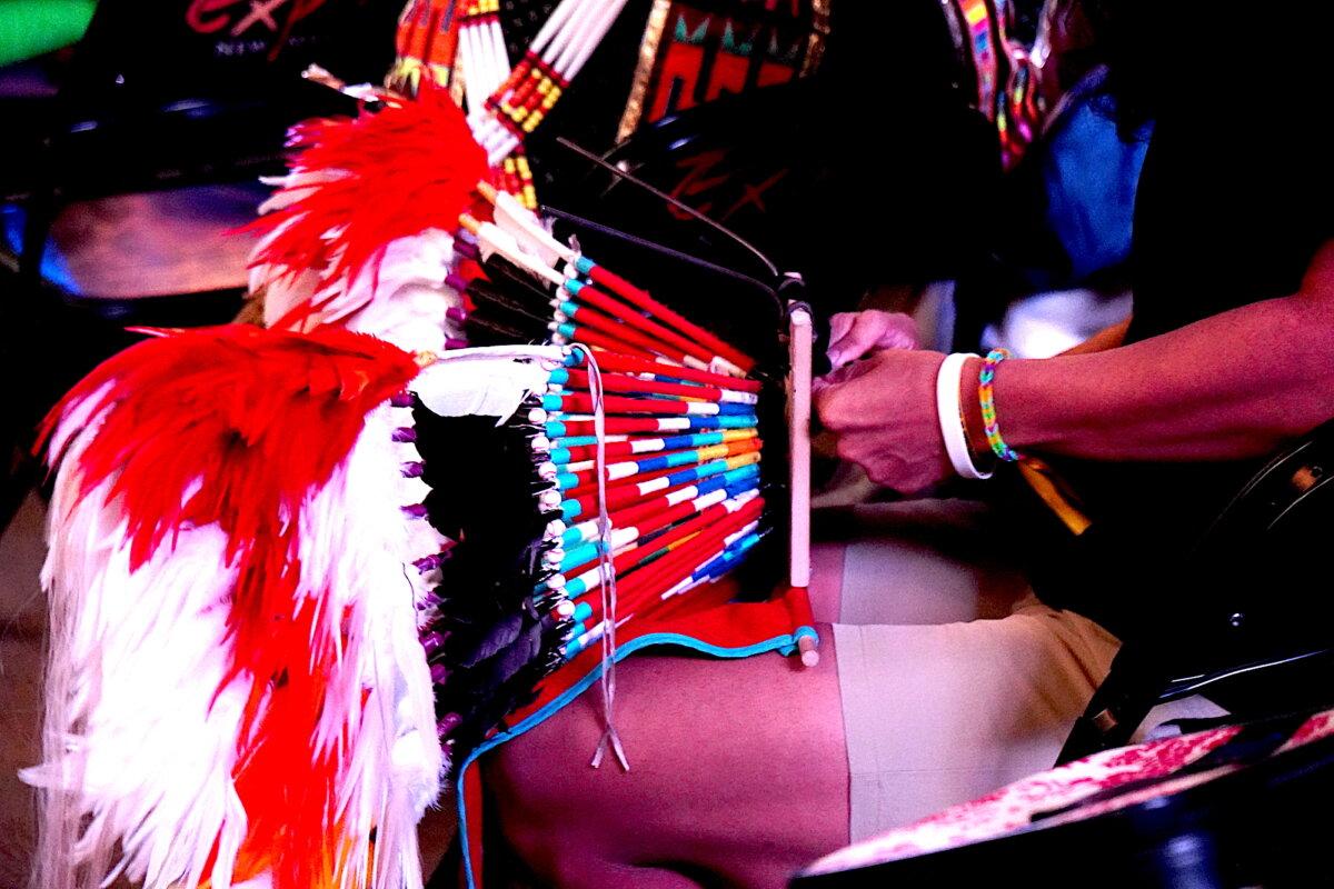 A participant at the 43rd final Gathering of Nations powwow in Albuquerque, N.M., works on a ceremonial costume on April 24, 2026. (Allan Stein/The Epoch Times)