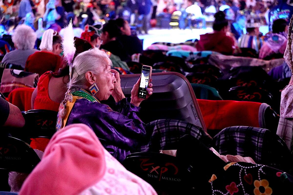A Native American woman touches up her makeup before dance performances inside the Tingley Coliseum in Albuquerque, N.M., on April 24, 2026. (Allan Stein/The Epoch Times)