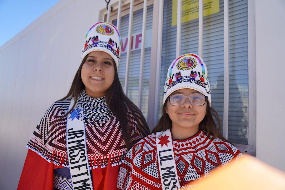 Ella Castillo, 14, (L) and Gabriella Rockefeller, 14, of the Fort Mojave Indian tribe in Needles, Calif., don ceremonial dance attire at the final Gathering of Nations powwow in Albuquerque, N.M., on April 24, 2026. (Allan Stein/The Epoch Times)