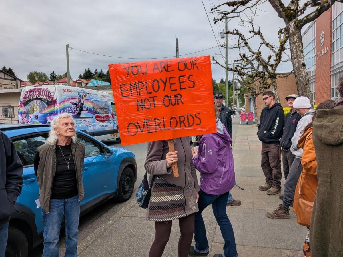 Cowichan Valley residents protest outside Cowichan Valley Regional District headquarters in Duncan, B.C., on April 22, 2026. (Paul Rowan Brian/The Epoch Times)