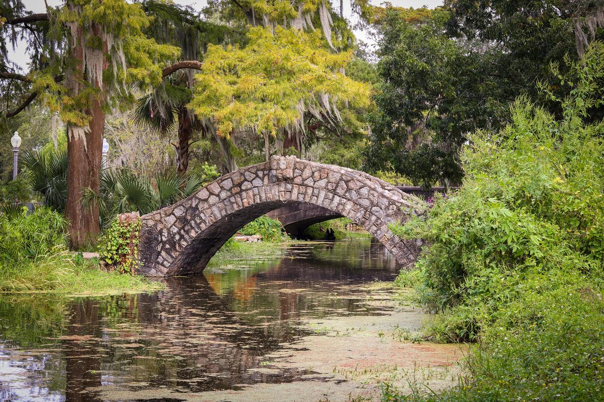 The Langles Bridge is a picturesque landmark near the entrance to City Park and one of its most photographed features. Spanning a tree-lined section of Bayou Metairie, it is one of three historic stone bridges in the park, constructed around 1902. (Felder Casanova/Shutterstock)