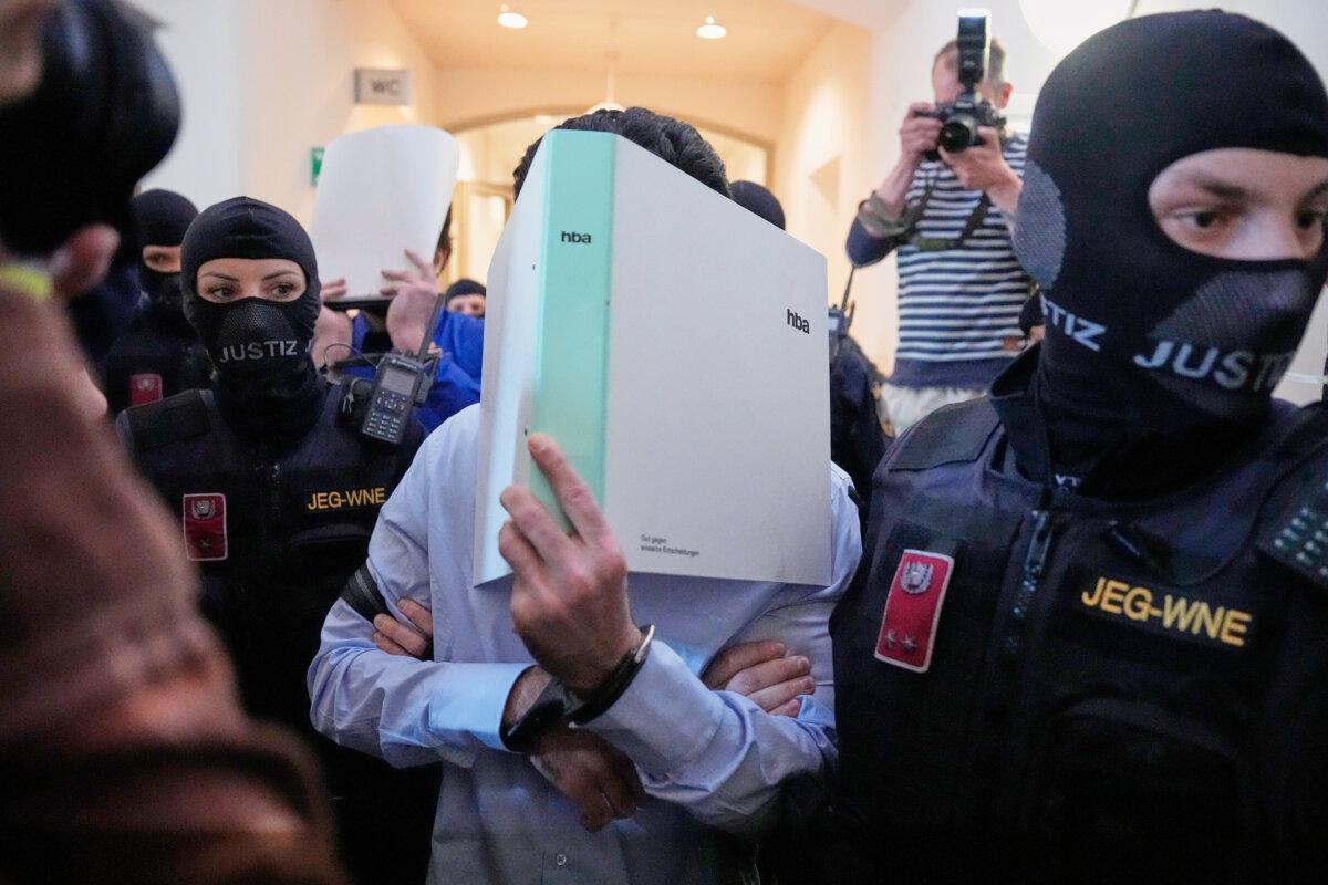 The defendants charged with terror-related offences, in connection to a plot targeting a Taylor Swift concert, hide their faces behind file folders on their way to the courtroom in the District Court in Wiener Neustadt, Austria, on April 28, 2026. (Matthias Schrader/AP Photo)