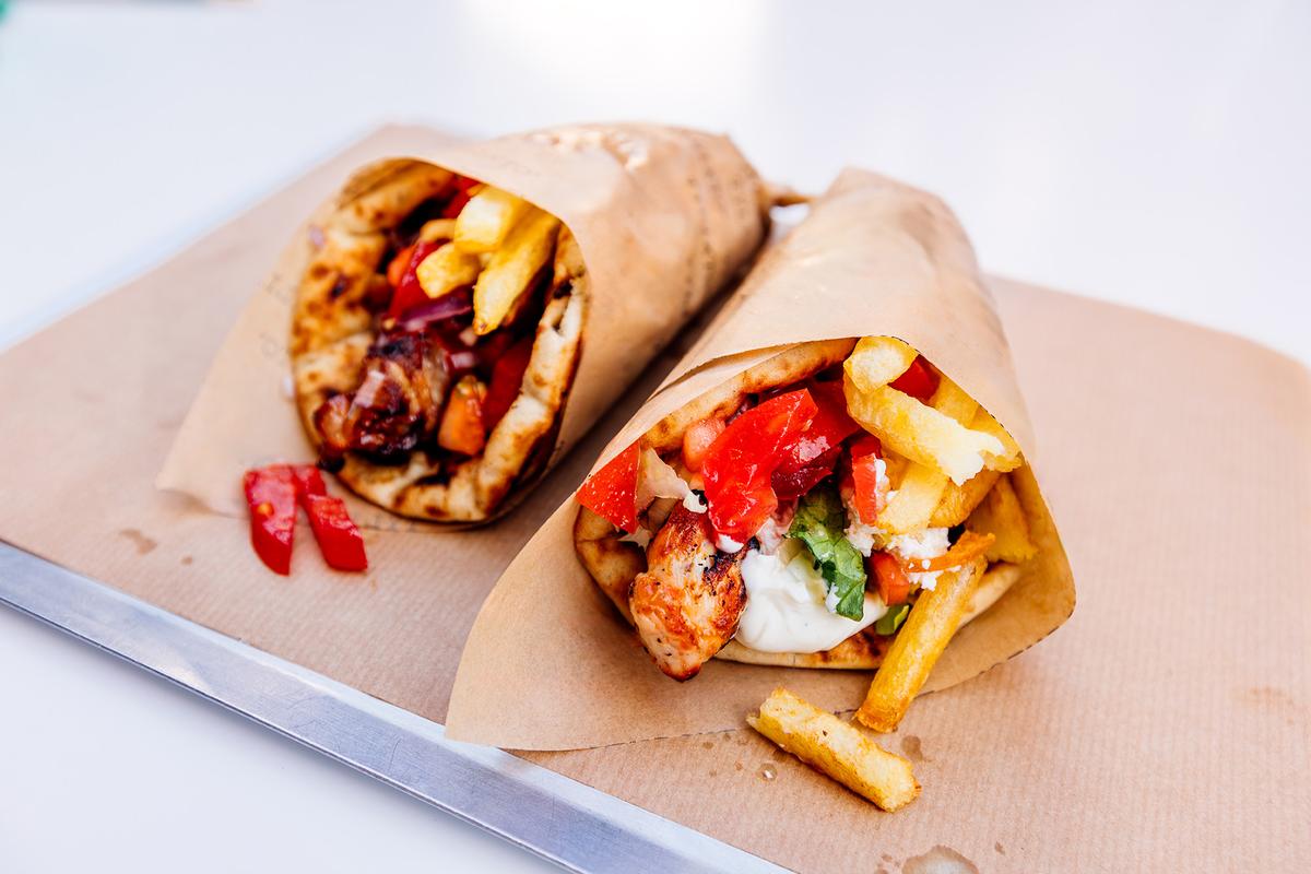 Chicken gyros served with tzatziki and fries. Gyros is a popular Greek street food made with seasoned, roasted meat sliced from a rotisserie. (Alexander Spatari/Getty Images)