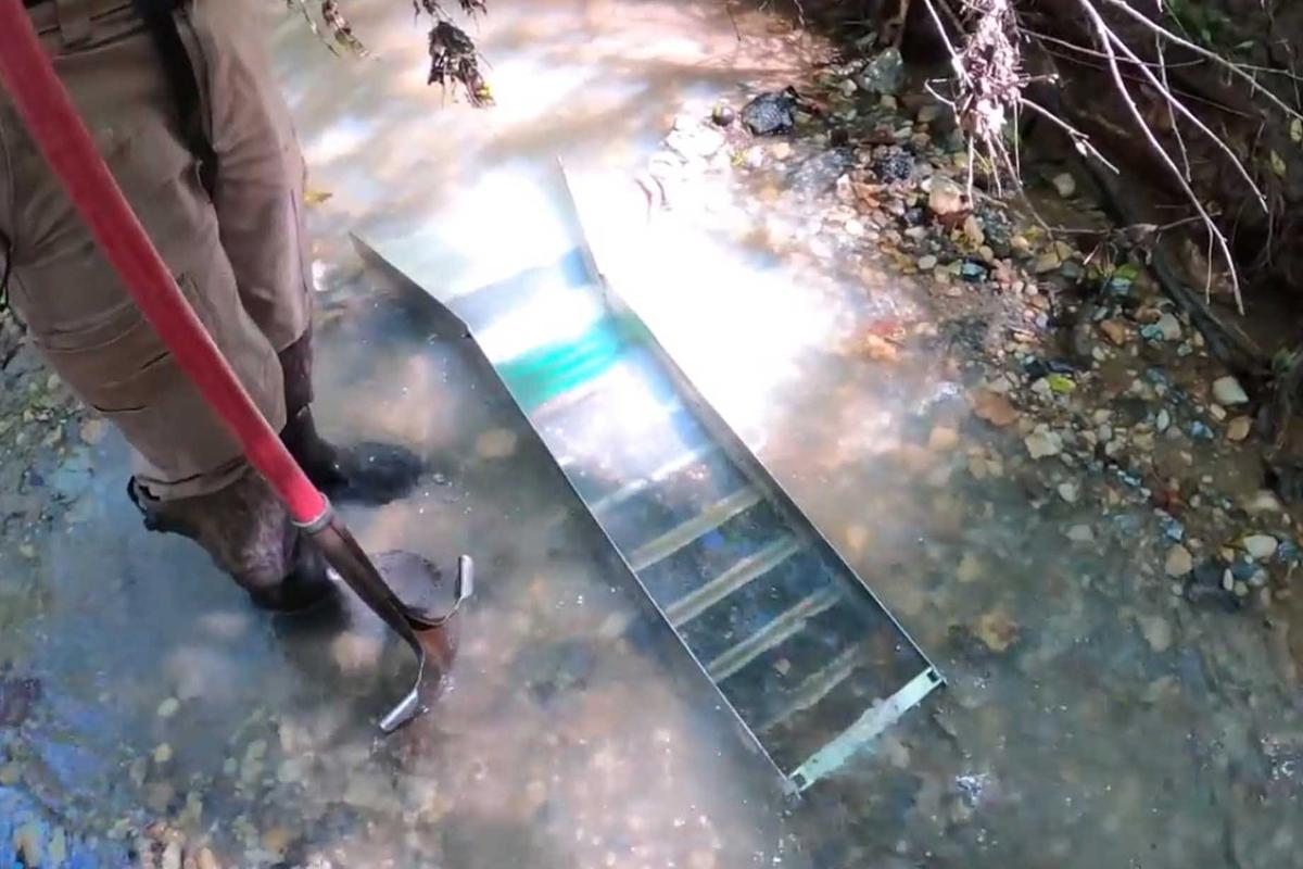 Denig shows off his sluice box, which allows the river to help sort his pay dirt shoveled from the river bottom. (Courtesy of Justin Denig)