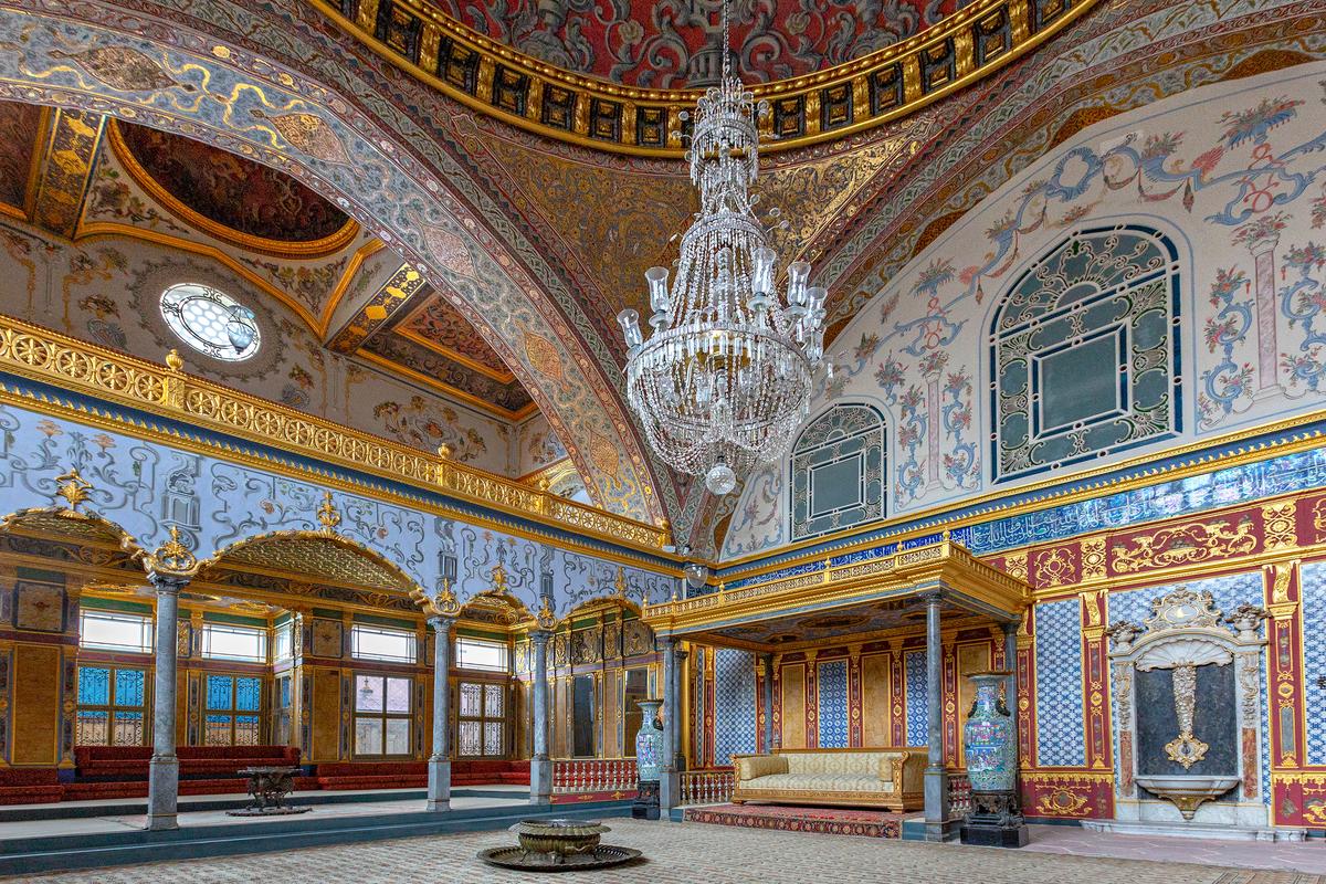 Built in the late 16th century, the Imperial Hall is a grand, ceremonial reception space later enriched in the 18th-century Ottoman Rococo style. It features vivid Delft tiles, painted panels, gilding, and intricate, finely carved woodwork. A massive, richly decorated dome rests on ornate pendentives, curved triangular elements that elegantly transition from a square base to the circular dome. (MehmetO/Shutterstock)