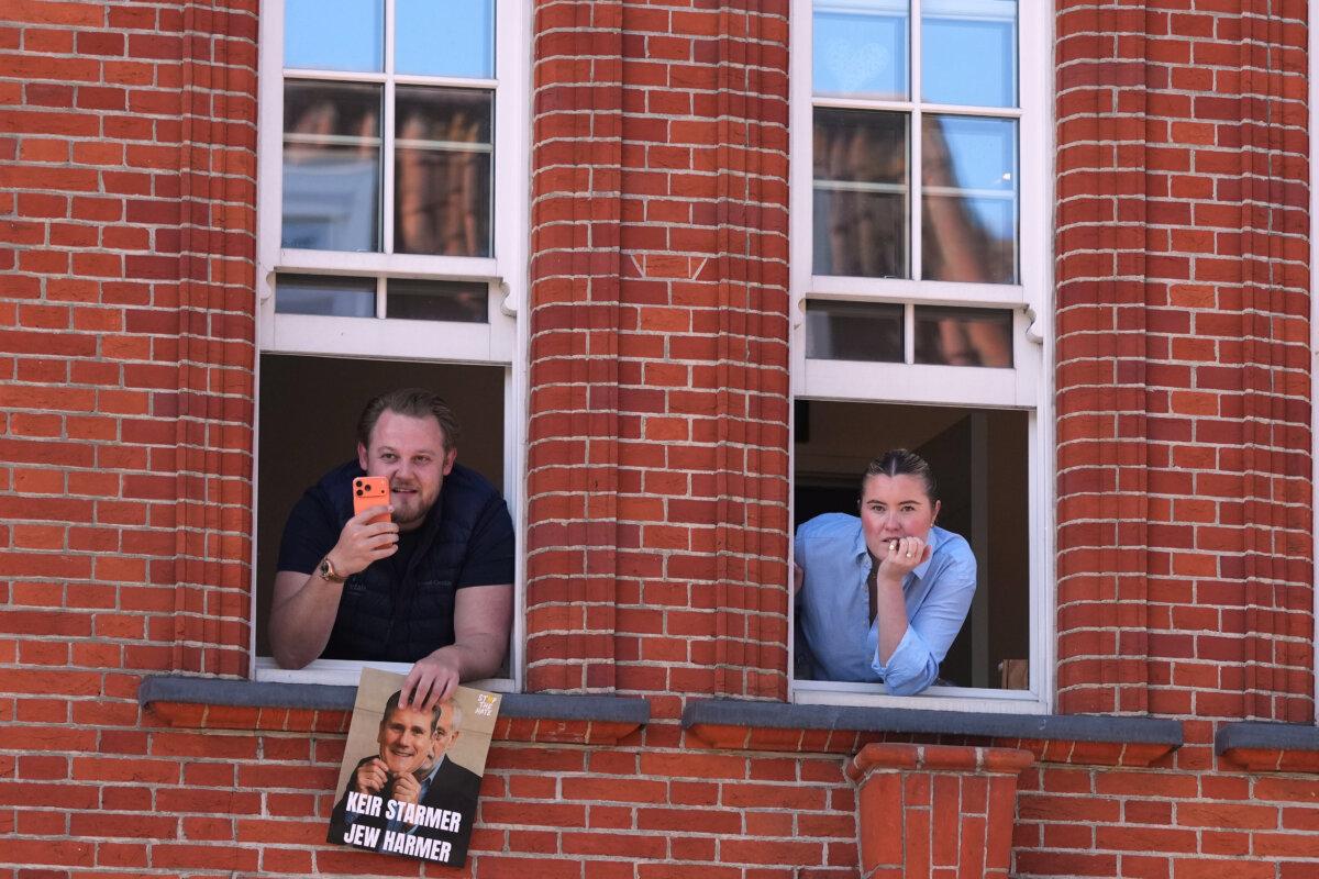 People look out of a window near the scene where two people were stabbed the previous day in the Golders Green neighbourhood, which has a large Jewish community, in London on April 30, 2026. (Alastair Grant/AP Photo)