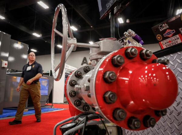 A delegate walks past pipeline equipment at the Global Energy Show in Calgary on June 10, 2025. (The Canadian Press/Jeff McIntosh)