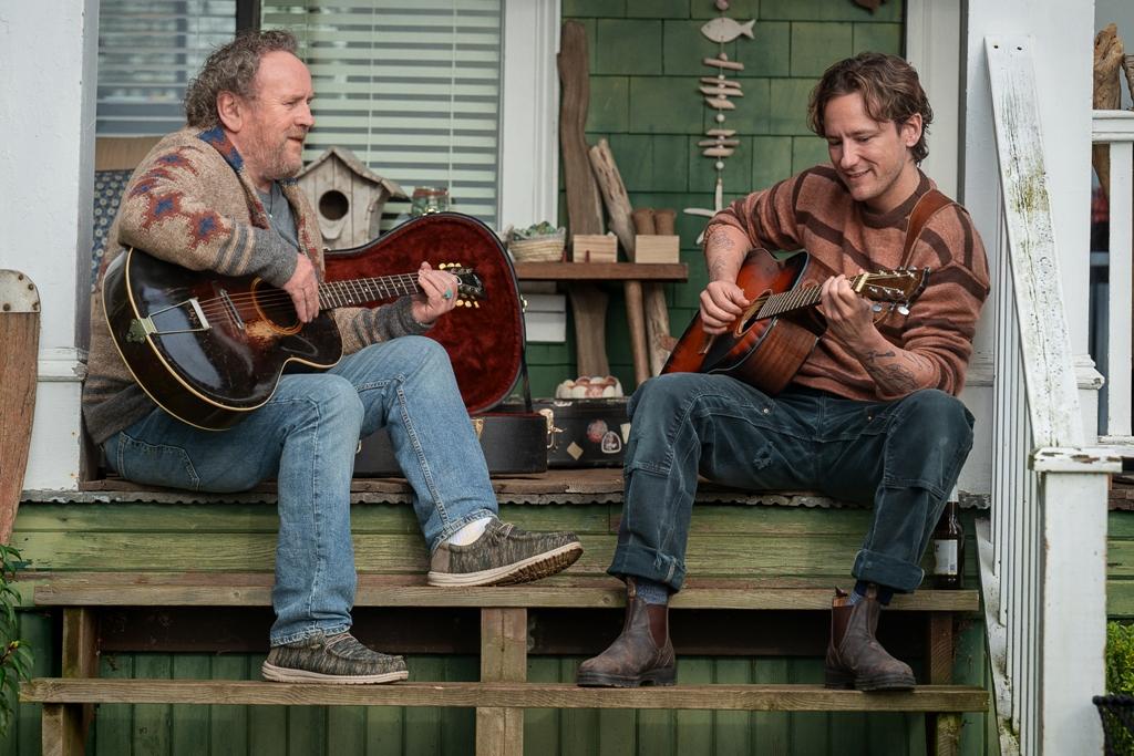 Ethan (Colm Meaney, L) and Cameron (Lewis Pullman) strum away, in "Remarkably Bright Creatures." (Netflix)