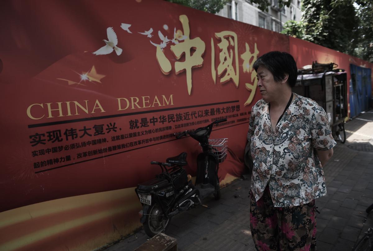 A woman looks at a banner about the "China Dream," Chinese leader Xi Jinping's vision for China's future, in Beijing on July 7, 2015. (Greg Baker/AFP/Getty Images)