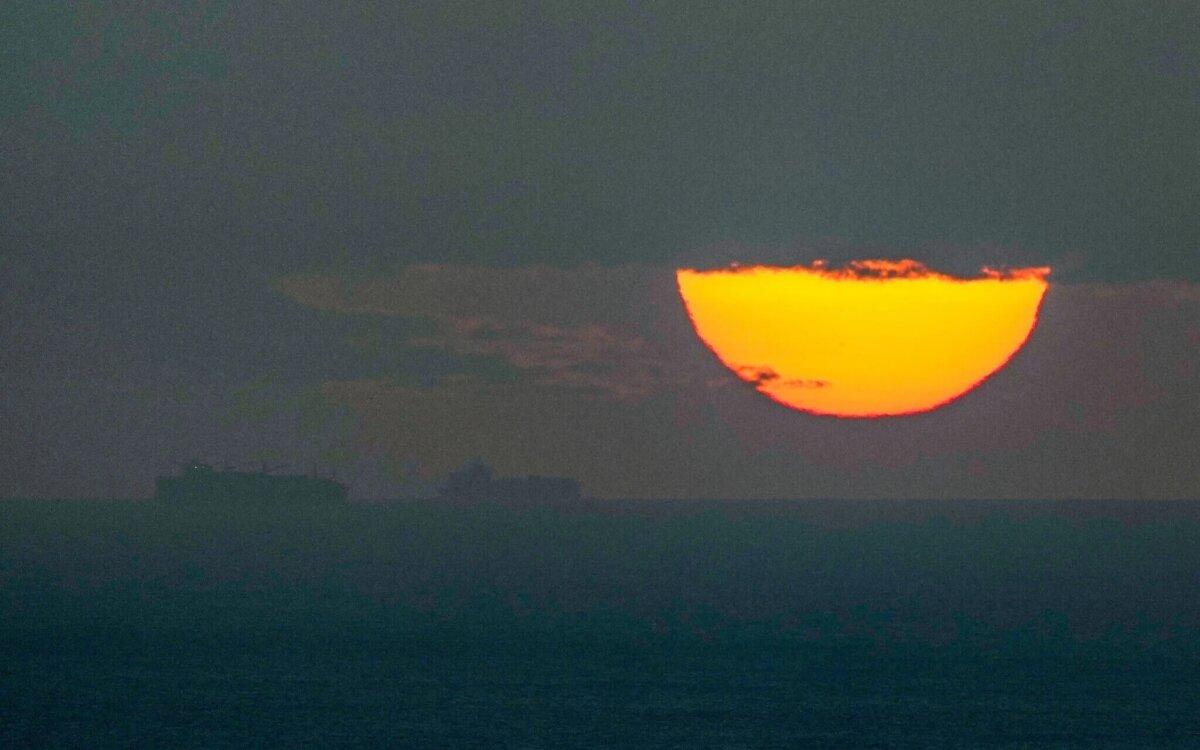 Ships sail through the Persian Gulf toward the Strait of Hormuz as the sun sets in the United Arab Emirates on March 23, 2026. (AP Photo)