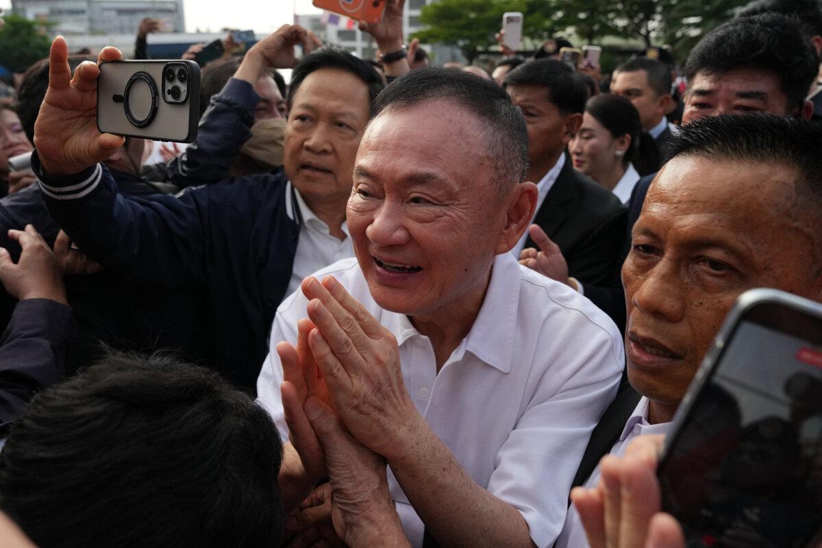 Former Thailand Prime Minister Thaksin Shinawatra, center, gestures to his supporters following his release on parole from prison in Bangkok on May 11, 2026. (Sakchai Lalit/AP Photo)
