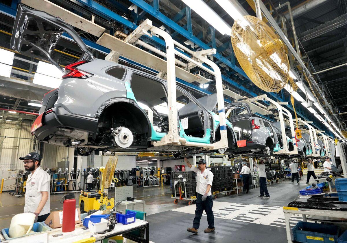Honda employees work along the vehicle assembly line before an event announcing plans for a Honda electric vehicle battery plant in Alliston, Ont., on April 25, 2024. (The Canadian Press/Nathan Denette)
