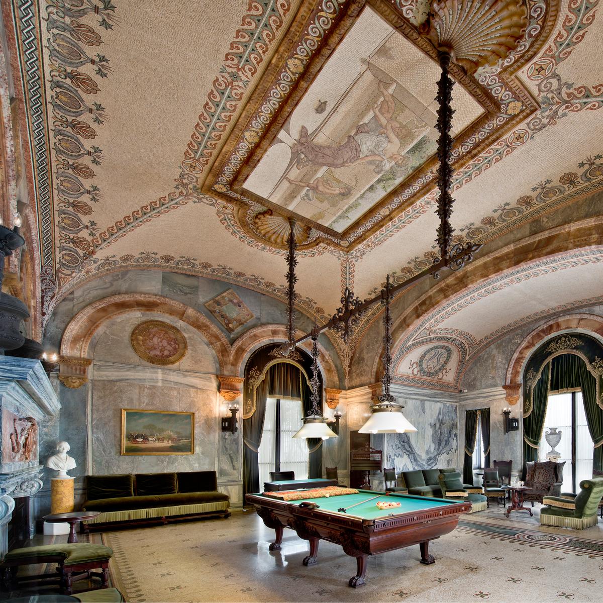 Also featured in “The Gilded Age,” the billiard room is wrapped in Cipollino marble, prized since Ancient Rome for its dramatic wavy bands of white, green, and gray. The hand-laid mosaic tile floor features a repeating pinwheel pattern of four acorns and oak leaves, symbolizing the "little acorn to a mighty oak" concept and reflecting the growth of the Vanderbilt fortune. (The Preservation Society of Newport County)