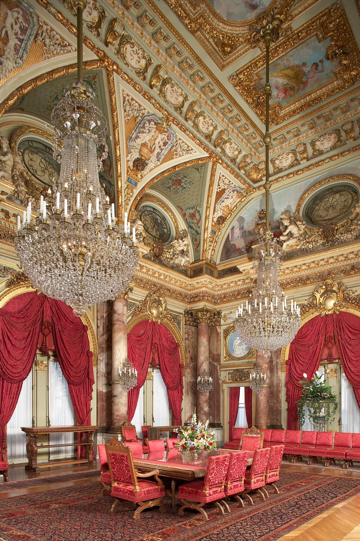 The grandest room in the house, the two-story dining room spans 2,400 square feet and can seat 34 at a carved oak table. Twelve alabaster Corinthian columns support a colossal gilt cornice. A ceiling painting of Aurora, the goddess of dawn, is framed by 22-karat gold leaf detailing, while two magnificent chandeliers hung with hand-cut crystals illuminate the room below. (The Preservation Society of Newport County)