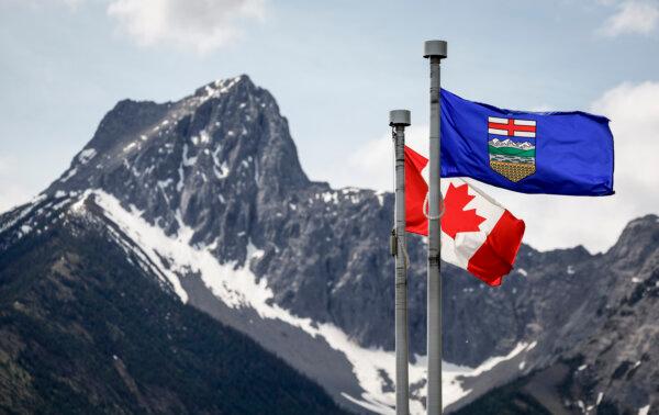 A Canada flag and an Alberta flag flap in the breeze with Wedge Mountain in the background at the site of the G7 Leaders meeting in Kananaskis, Alta., on June 2, 2025. (The Canadian Press/Jeff McIntosh)