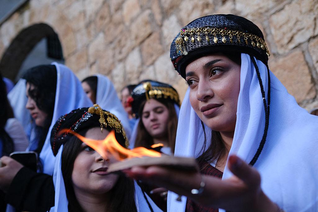 Yazidi women light candles during a ceremony marking Charshama Sor, or Red Wednesday, the Yazidi New Year, at Lalish temple in Shaikhan near Dohuk in northern Iraq on April 14, 2026. Northern Iraq's Kurdistan Region is home to the Yazidi religious minority, which was attacked and displaced by ISIS militants in 2014, when hundreds of people were taken hostage, including women who were allegedly used as sex slaves. (Gailan Haji/Middle East Images/AFP via Getty Images)