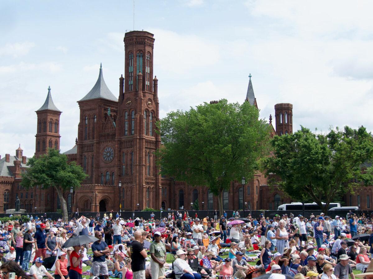 Thousands of Americans gather on the National Mall for the Rededicate 250 celebration, with the Smithsonian Castle in the background, in Washington on May 17, 2026. (Travis Gillmore/The Epoch Times)