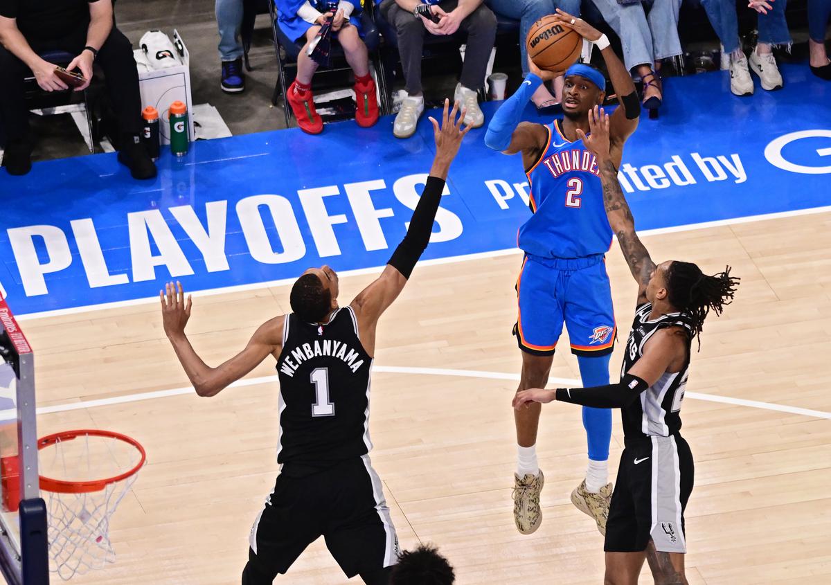 Shai Gilgeous-Alexander #2 of the Oklahoma City Thunder shoots the ball against Victor Wembanyama #1 and Devin Vassell #24 of the San Antonio Spurs during the third quarter in Game 1 of the NBA Western Conference Finals at Paycom Center in Oklahoma City, Okla., on May 18, 2026. (Joshua Gateley/Getty Images)