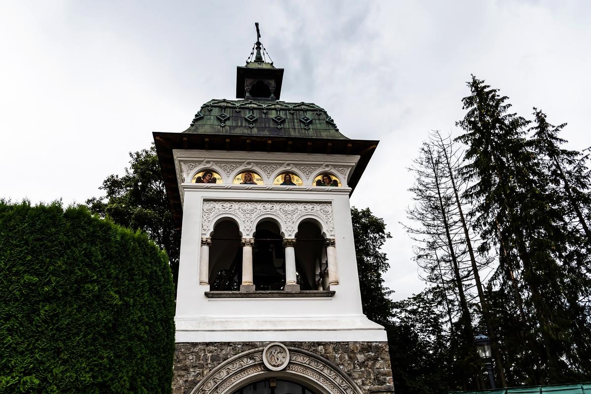 Dating to the late 19th century, the bell tower features trilobed arches, a clover-shaped curve common to Brâncovenesc architecture. The tower affords broad views over the forested landscape below. Its 3,700-pound bell, brought from the Colțea Tower in Bucharest, continues to ring out across the forested valley below. (Adriana Sulugiuc/Shutterstock)