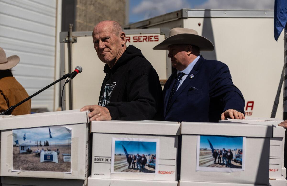 Mitch Sylvestre (L) prepares to submit signatures for a separation referendum to Elections Alberta in Edmonton, on May 4, 2026. (The Canadian Press/Jason Franson)